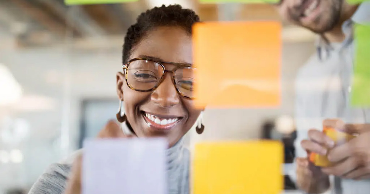 Mulhher sorrindo para exemplificar o quanto é importante ser feliz no trabalho